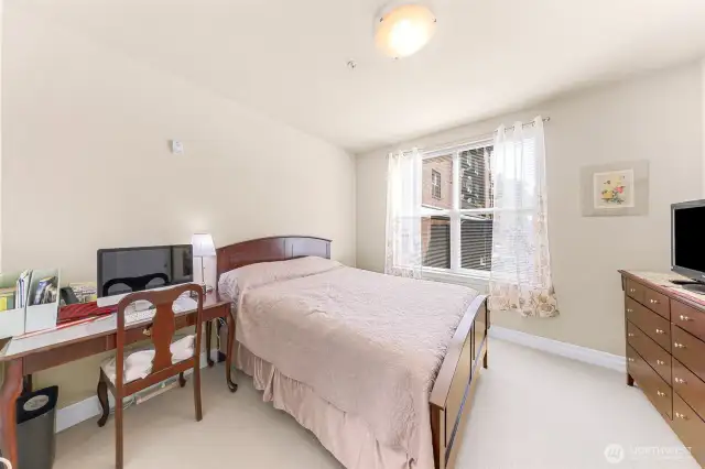 Serene guest room with room for a desk.
