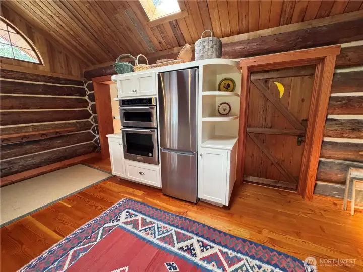 Local fir milled on-island and installed by locals. Custom cabinetry and "moon" door designed and built by local craftsman, Brian Himlan. Door accesses the guest bath and laundry.