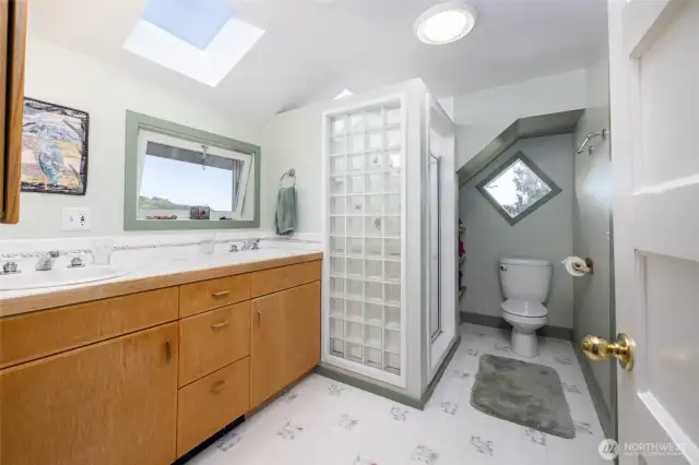 Upstairs primary ensuite 3/4 bath features a double vanity, skylight, and step in shower.