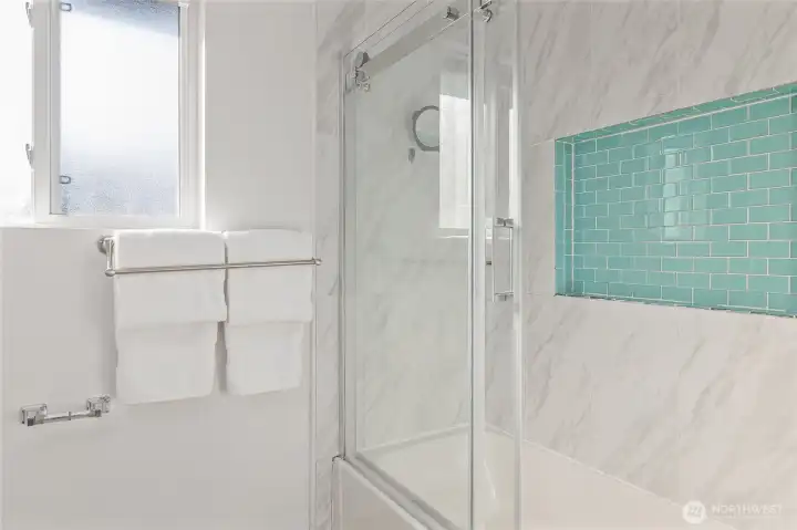 Hall bath with glass tub/shower enclosure with large tile niche.