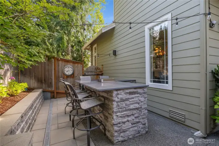 Outdoor custom bar with seating, fridge and sink