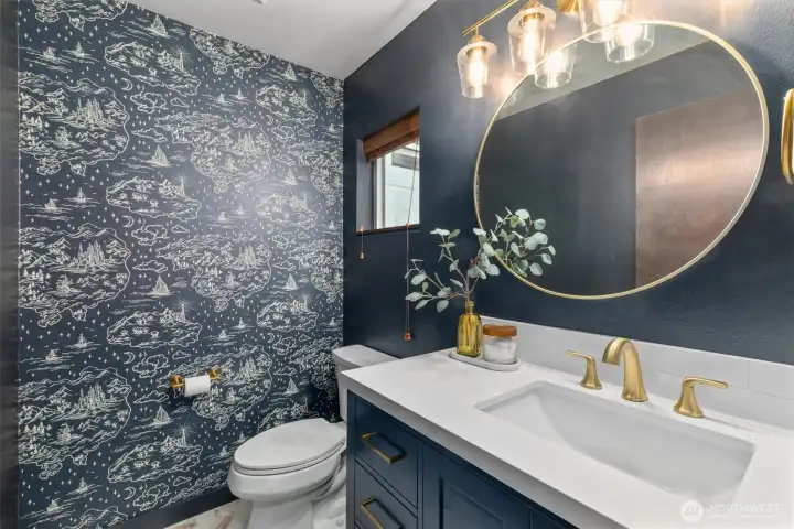 Remodeled half bath featuring new vanity, hardware, lighting and whimsical wallpaper