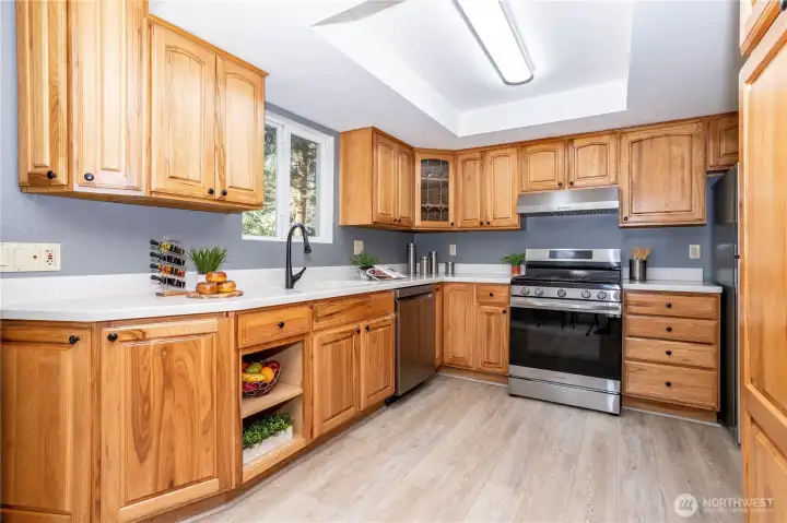 The kitchen feels bright, functional and refreshed with a layout designed for everyday ease. Natural wood cabinetry brings warmth to the space, paired nicely with updated counters and modern appliances. There’s ample storage throughout, and the L-shaped configuration keeps everything within reach while cooking. The flooring continues in from the living areas, keeping the transition cohesive rather than segmented.
