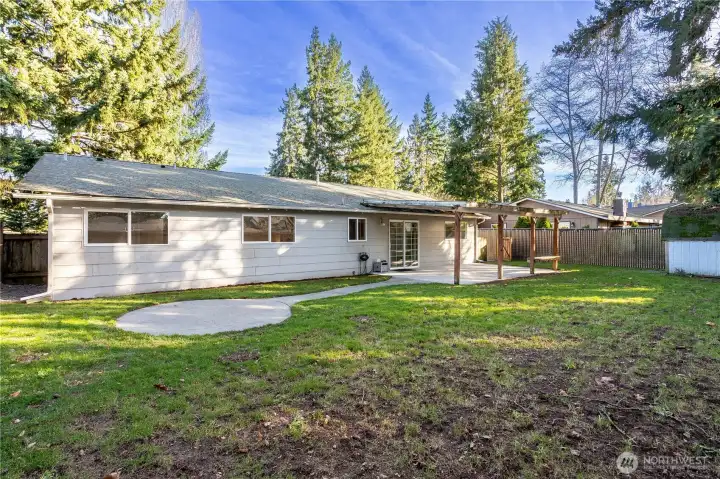 From this angle, you can see the full rear elevation of the home and how it connects to the outdoor living areas. The covered patio anchors the backyard, while the lawn extends outward for additional flexibility. The home’s exterior appears well-maintained, and the lot feels open with room to enjoy without feeling exposed.