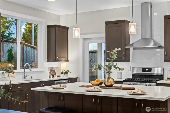 The warm lighting throughout the kitchen is highlighted here.  The glass door to the covered deck and large window over the sink bring in plenty of additional natural light.