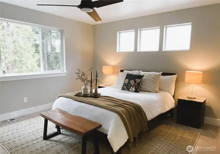 The primary bedroom is a spacious retreat and also abundantly private.  The large evergreen provide enough privacy making window treatments optional.