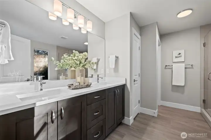 The primary bathroom includes quartz counters, double sinks, tile floors and linen closet