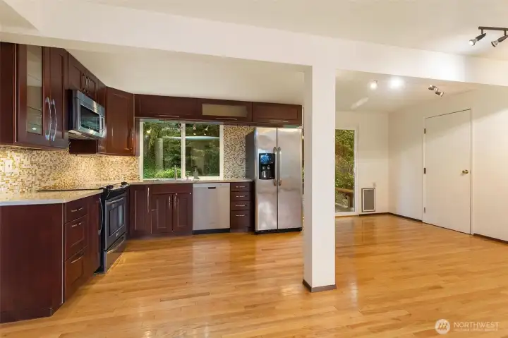 Kitchen features modern appliances, rich cabinetry, and a convenient dining area