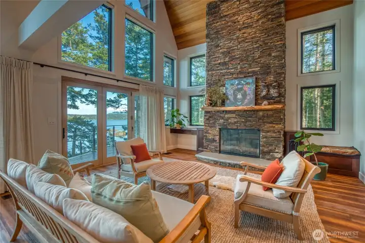 Be a part of the outdoors while sitting cozy warm in front of this large stone fireplace. Floor to ceiling windows showcase the views across East Sound and brings nature into your home.