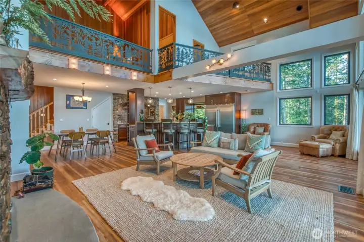 Open floor plan shares dining, kitchen and living room space, with upper loft area.