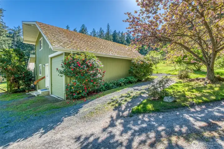 Multi purpose building houses two guest units, a lower studio and an upper apartment (currently rented year round). Vacation Rental  permit offers opportunities. Large shop/garage and basement storage/utility space. This building sits adjacent to the greenhouse, fenced garden and orchard.