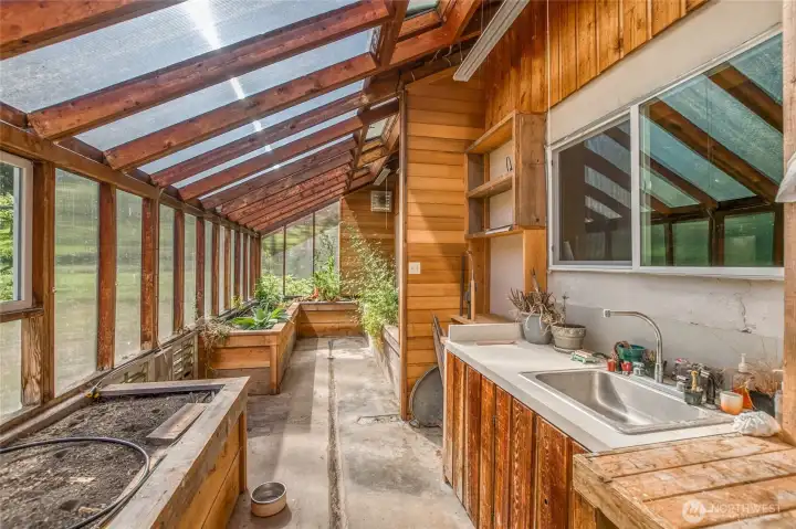 Ok... you had me at greenhouse!!! This space has it all, plumbing, fans, windows, raised beds, irrigation, counter space and views to the garden and orchard.