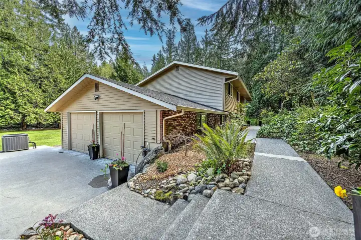 Plenty of parking and nice walkway up to the front entrance. Lush native plants and a tree lined border around the property.