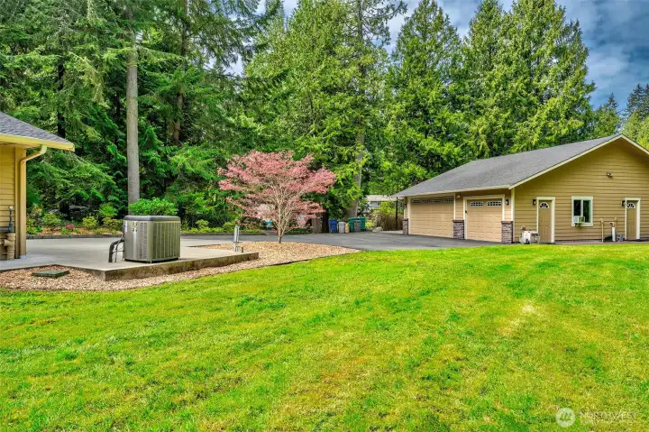 1290 sq ft Shop/Garage in relationship to the main house. Generator hook up is piped next to the Heat pump.