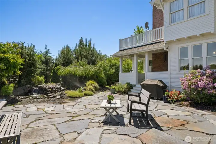 View of patio space with pond and waterfall outside kitchen eating space and covered porch off eating space.