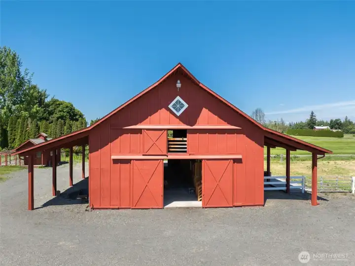 Four stall barn with tack room, wash bay, cattle pen in back, paddocks off four stalls, room for more stalls.