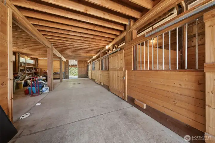 View of four stalls. Tack room to the left, wash bay on left, space for more stalls.