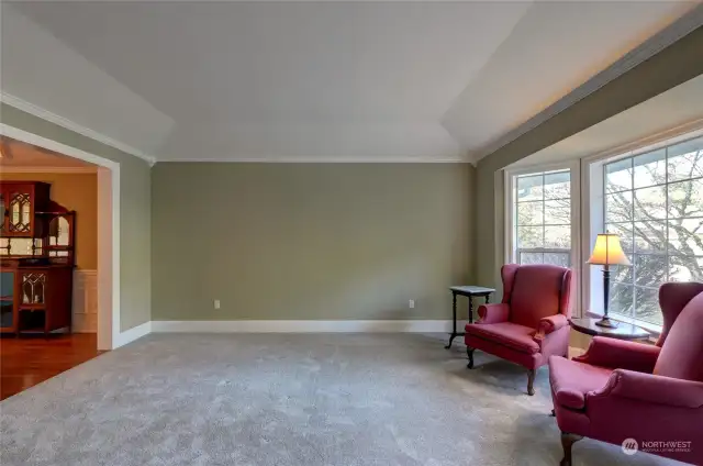 Coved ceilings grace the living room, that is adjacent to the spacious dining room