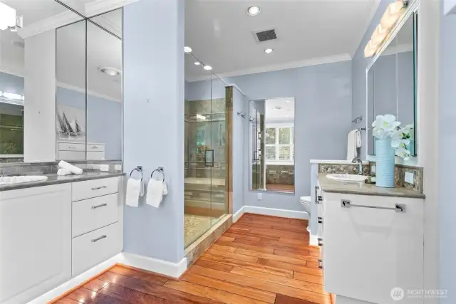 The spacious primary bath is thoughtfully designed with a luxurious soaking tub, a large tiled shower, and two separate vanities—blending spa-like comfort with timeless functionality in a beautifully appointed setting.