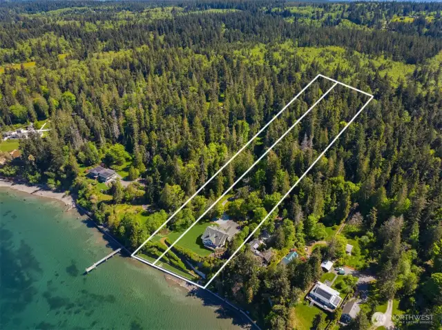 From above, the property’s expansive footprint comes into view—over 7 acres of pristine land stretching to 254 feet of private shoreline. The setting offers rare seclusion, a protected cove, and endless potential for outdoor enjoyment or future vision.
