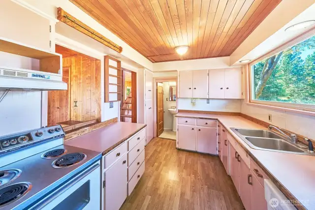 Old school Seaview kitchen, looking west toward the back of the house. Pass through and entrance by stairs on your left. Large window over the sink.