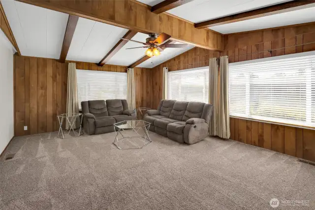Formal living room with cathedral ceiling and fan.