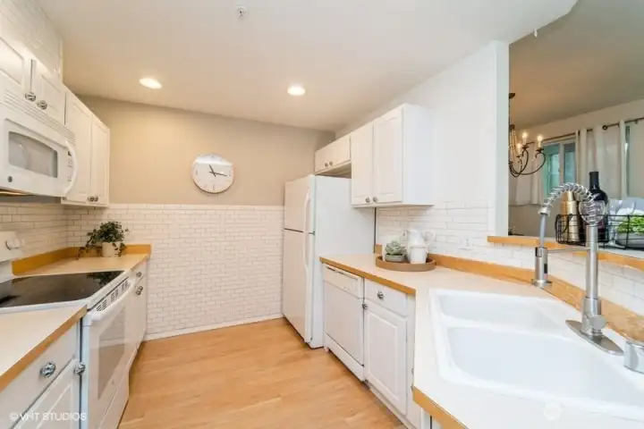 This bright kitchen features an abundance of subway tile, creating a clean and modern look.