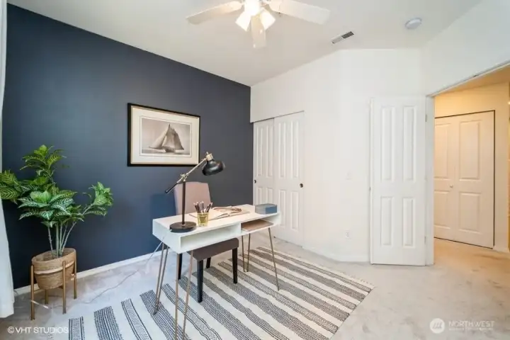Walk through the double doors into the inviting 2nd bedroom, featuring an accent wall and a ceiling fan for added comfort. This space is perfect for guests or as a cozy retreat.