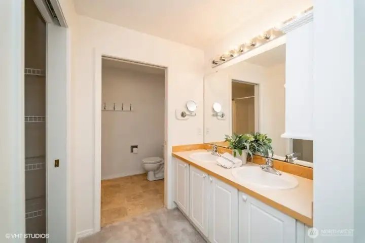 The primary bath features double sinks, plenty of counter space, and ample cabinetry, providing ample storage for all your bathroom essentials.