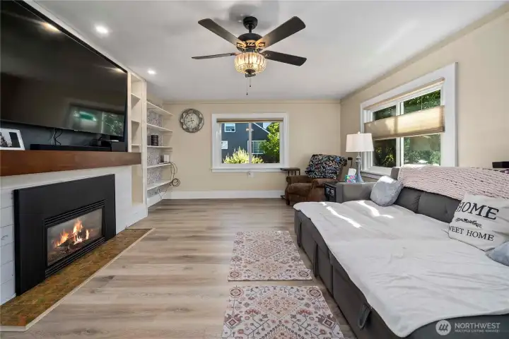 Another view of the living room showing the built-in display shelves on the far side of the fireplace.