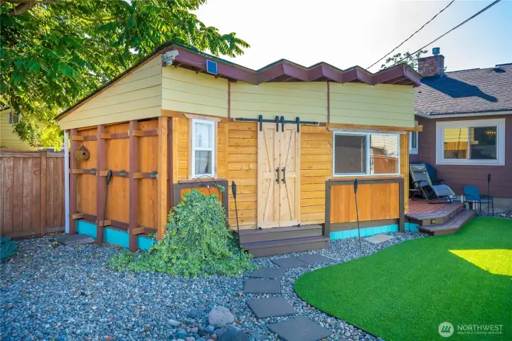 This is the side view of the darling additional room off of the deck, with its own porch and a barn door. What a bonus feature of the home.