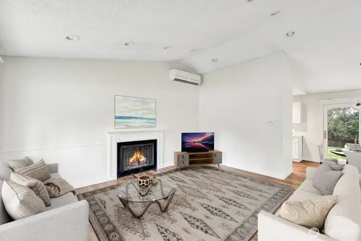 Living room with vaulted ceilings and fireplace.