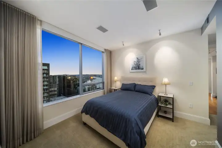 Primary Bedroom with city and water views and mechanical shades to block out the city lights