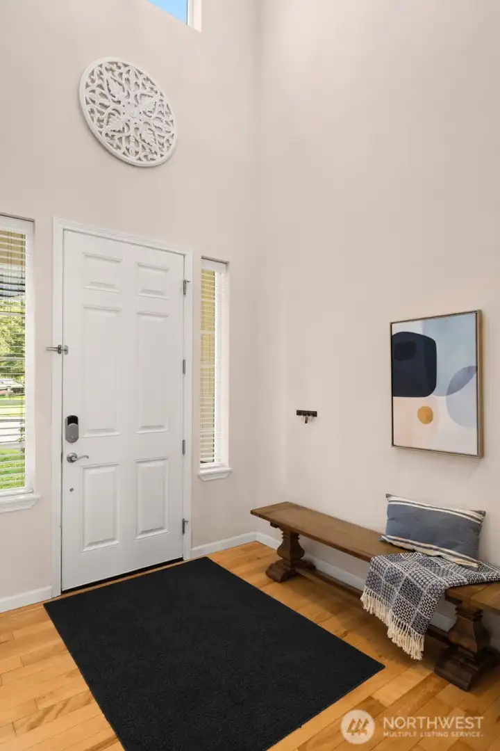 Inside, you are greeted by a 2-story foyer and rich hardwood floors. Windows on both sides of the front door plus the clerestory window above fill this space with natural light. There is a lighted art nook just out of view.