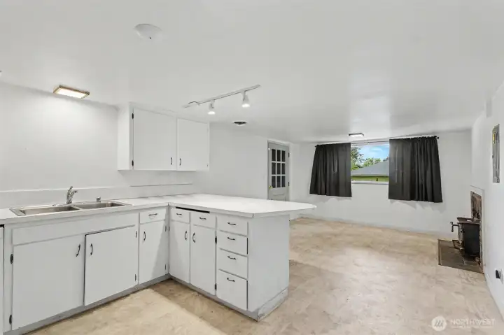 Kitchen features a peninsula with seating, room for dining, and a pass-through opening that creates a subtle connection to the living room.