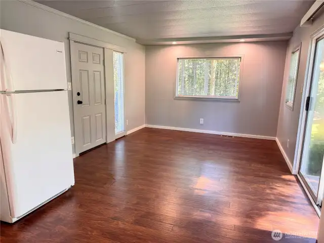 Living room with windows on 3 sides plus a sliding door out to a small deck.