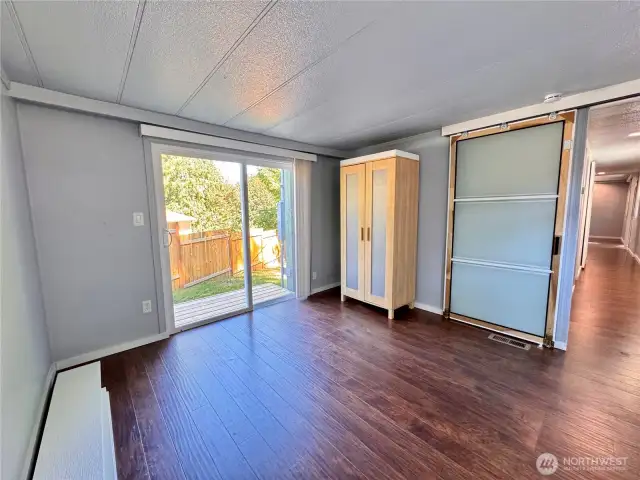 Bedroom #1 with a slider out to a small deck. Barn door.