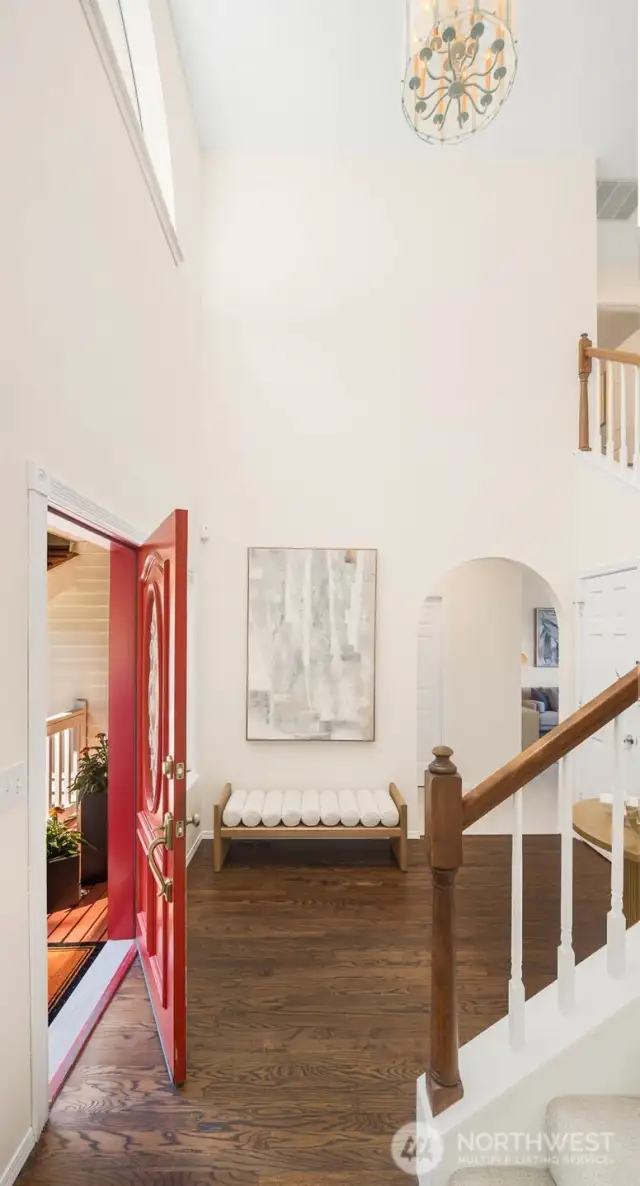 Spacious entry way with soaring ceilings, oak hardwood floors, and arched doorways that lead both to the rec room and living room.