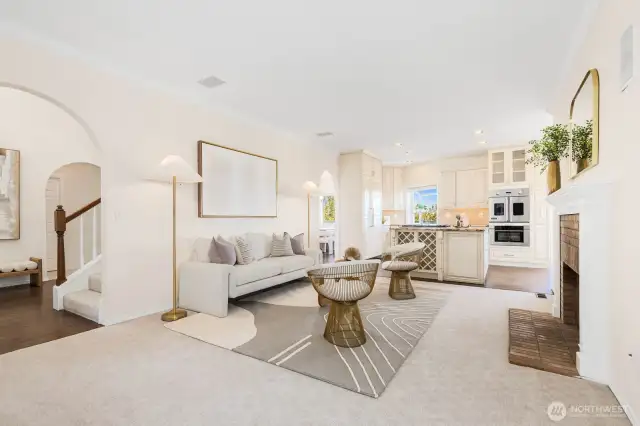 Open concept living with high ceilings looking from the sitting room into the living room, entry and kitchen.