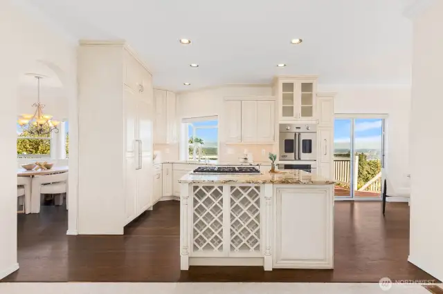 Kitchen island boasts wine rack, hidden wine fridge, 6 burner gas cooktop, and pop up shelf for easy mixer storage. High end appliances camoflauged by cabinet faces. Discover how to use a steam oven!