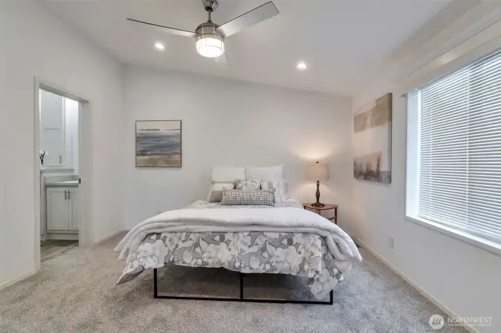 Primary Suite with vaulted ceilings, opens to double sink ensuite bathroom. Ceiling fan and walk-in closet.