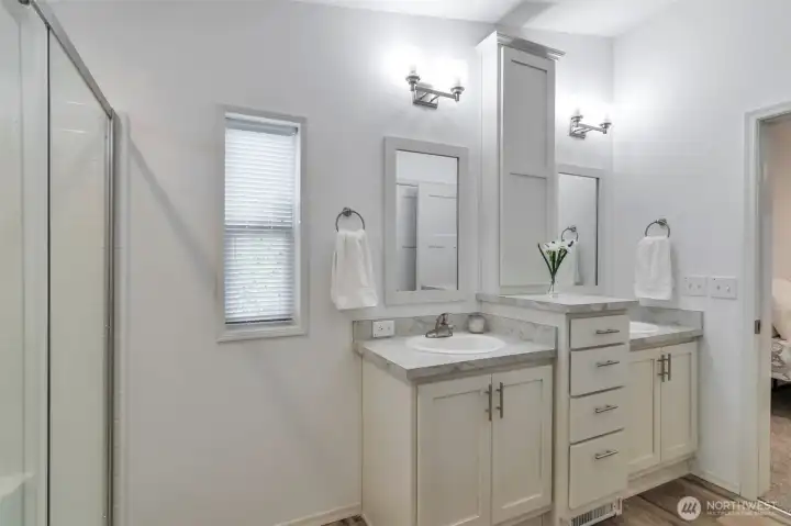 Raised height, double sink vanities with storage. Tucked around the corner is a water closet and linen storage cupboard.