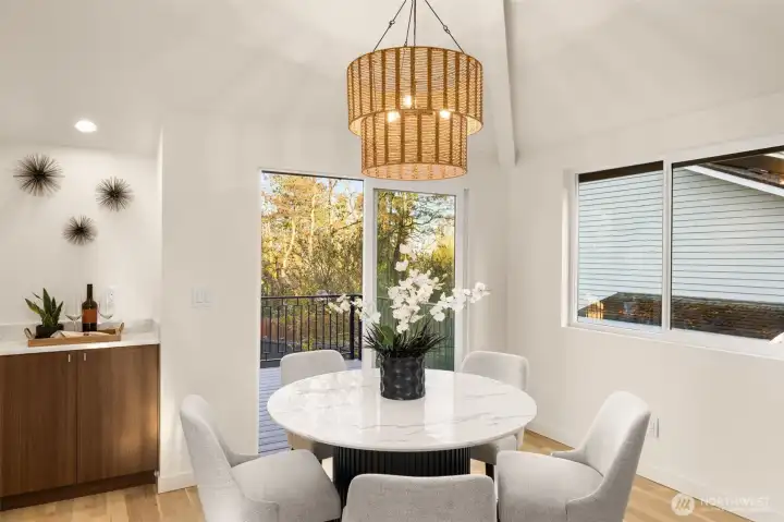The dining area is flooded with an abundance of natural light from the connected deck