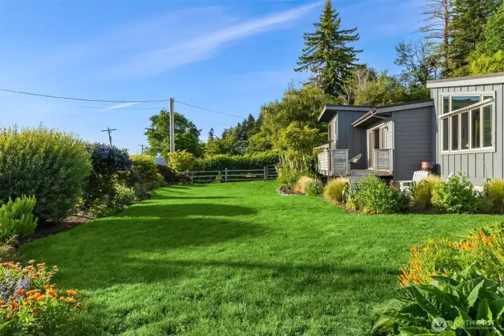 Flat grassy area surrounds the home. Flat grassy area surrounds the home.