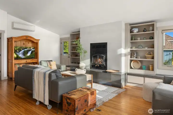 The main living room connects to the kitchen and dining room and has a cozy wood stove with built-ins surrounding it. The main living room connects to the kitchen and dining room and has a cozy wood stove with built-ins surrounding it.