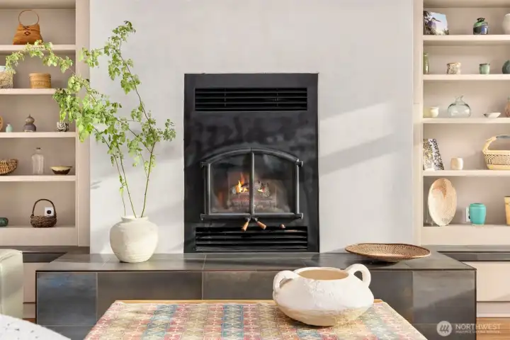 A close up of the wood stove, modern tile surround and built-ins. The home was freshly painted inside. A close up of the wood stove, modern tile surround and built-ins. The home was freshly painted inside.