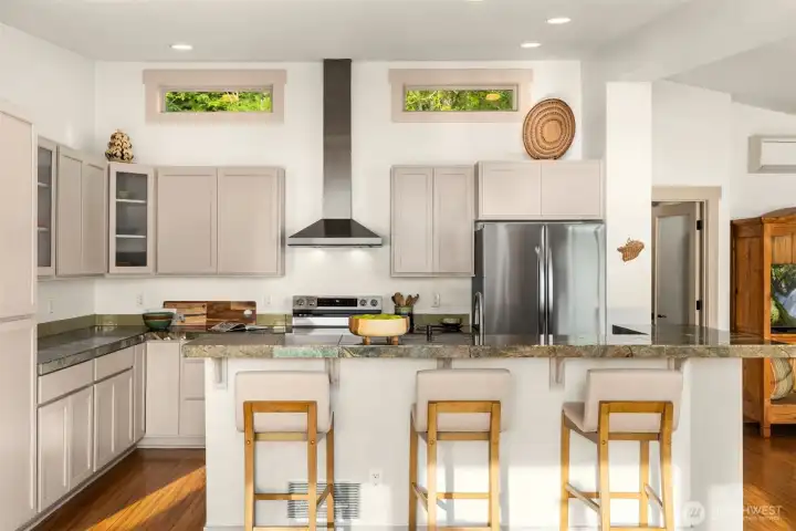 The open kitchen has a central island, terrific storage space and updated stainless steel appliances. The open kitchen has a central island, terrific storage space and updated stainless steel appliances.