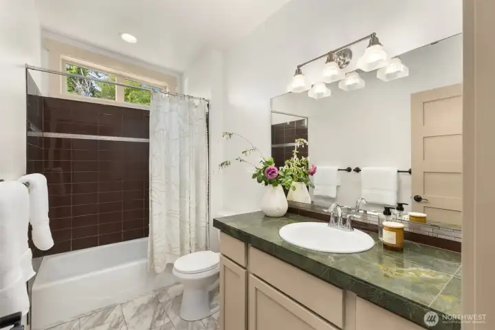 The main hallway bathroom with a tiled tub and shower combo. The main hallway bathroom with a tiled tub and shower combo.