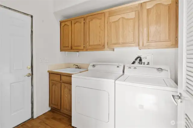 Utility Room with laundry sink & lots of storage! Washer & Dryer stay. Access the 2 car attached garage from here.