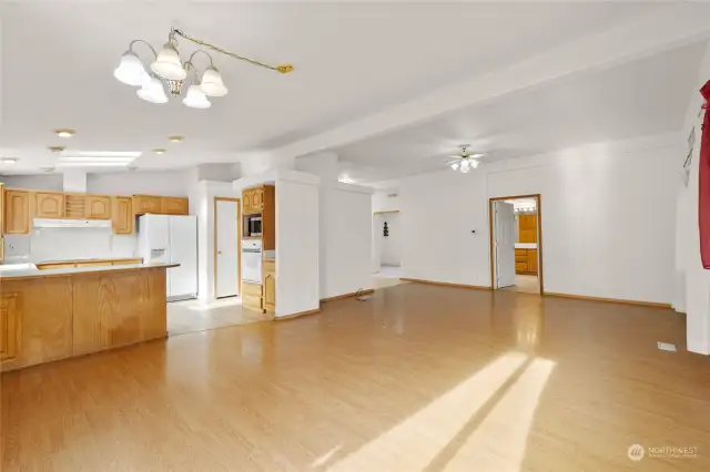 From the dining space, looking back towards the living space, primary bedroom entry, & kitchen.